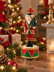 Carillon natalizio Soldatino Schiaccianoci con Albero EDG H22 cm ambientato su una consolle decorata per Natale, con luci calde e addobbi natalizi.