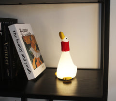 Lampada da notte Winkee Goose Snuggle oca illuminata su mensola
