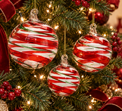 Palle di Natale Vortex EDG Enzo De Gasperi in vetro rosso e verde Ø 8, Ø 10 e Ø 12 cm ambientate su albero di Natale illuminato